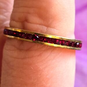 Vintage ring with red gems all the way around thin band gold tone